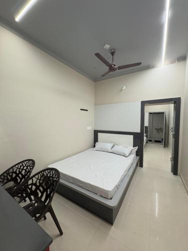 a bedroom with a bed and two chairs in it at vMAC in Thiruchendur