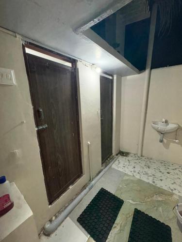 a bathroom with a wooden door and a sink at vMAC in Thiruchendur