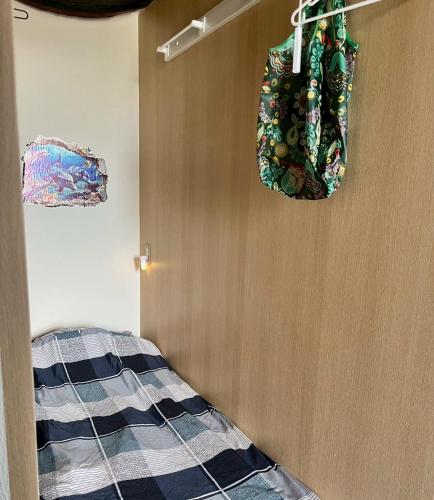 a bedroom with a bed and two bags hanging on the wall at ゲストハウスブルーオーシャン那覇 in Naha