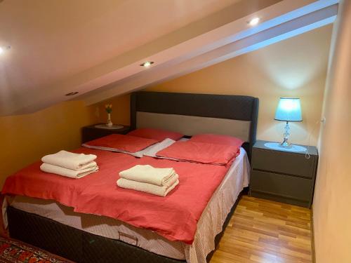 a bedroom with a bed with red sheets and towels at Mariana in Gori