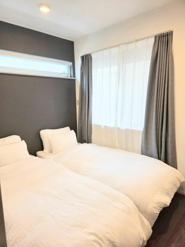 two beds in a bedroom with a window at Kichi in Tokyo