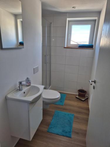 a bathroom with a sink and a toilet and a window at Zimmervermietung Müller in Kelheim