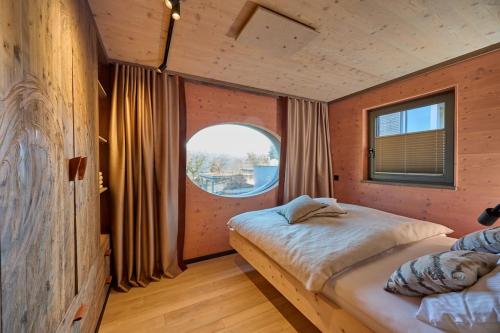 a bedroom with two beds and a round window at Exklusive Ferienlodge in Wertheim
