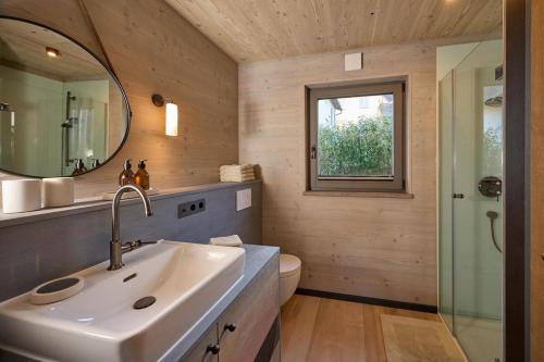 a bathroom with a sink and a toilet and a mirror at Exklusive Ferienlodge in Wertheim