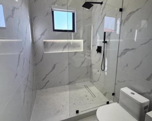 a bathroom with a shower with a toilet and a window at The Grand Avora Apartment With 3 Ac And Free Parking in Lahore