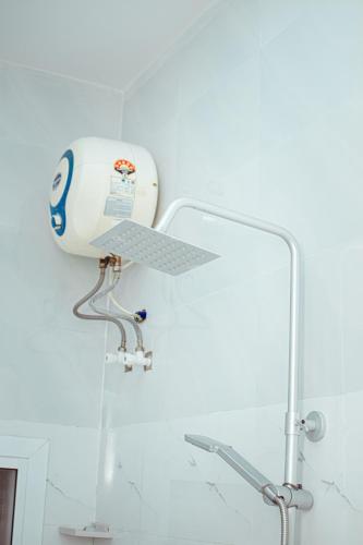 a shower in a bathroom with a machine on the wall at Bandari House Malindi in Zanzibar City