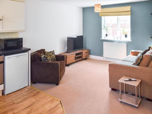a living room with two couches and a tv at Coops Nest in Stalham