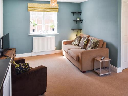 a living room with a couch and a window at Coops Nest in Stalham