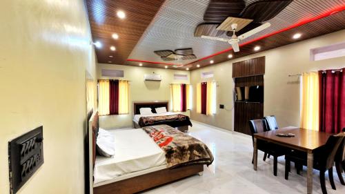 a bedroom with a bed and a table and a desk at Sand Dunes Stay in Bagru
