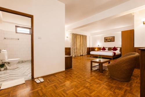 a hotel room with a bed and a bathroom at Sparrow Chiminda A-Heritage Hotel Middle Pelling in Pelling