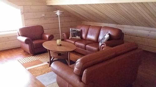 a living room with brown leather furniture and a table at Villa Älgen in Bamböle