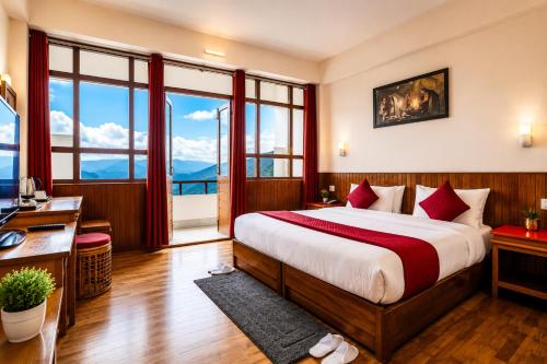a bedroom with a bed and a desk and windows at Sparrow Chiminda A-Heritage Hotel Middle Pelling in Pelling