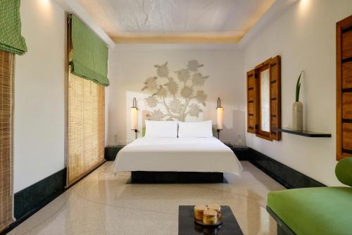 a bedroom with a white bed and a couch at RAAS Devigarh in Udaipur
