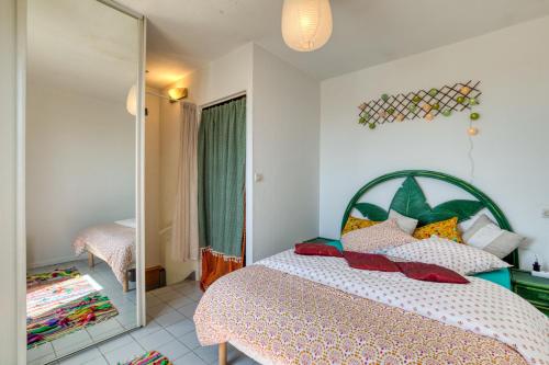 a bedroom with a bed and a mirror at Le Duplex des Halles-Balcon & Clim in Sète