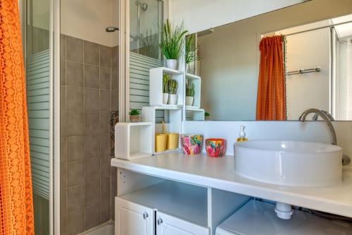 a bathroom with a sink and a mirror at Le Duplex des Halles-Balcon & Clim in Sète