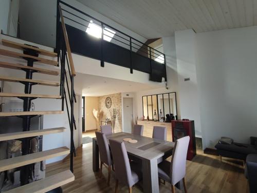 a dining room and living room with a table and chairs at Augustobona in Lévigny