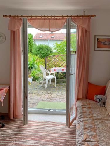a bedroom with a bed and a sliding glass door at FeWo im Dreiländereck in Büchlberg