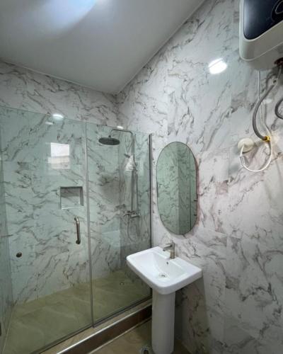 a bathroom with a sink and a shower at Blooms Manor Apartment in Lagos