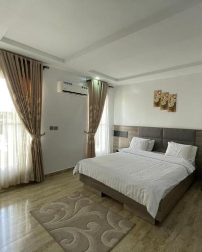 a bedroom with a large bed and a large window at Blooms Manor Apartment in Lagos