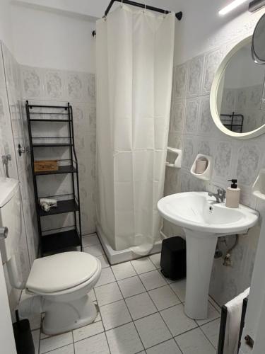 a white bathroom with a toilet and a sink at Angelika Rooms in Longá