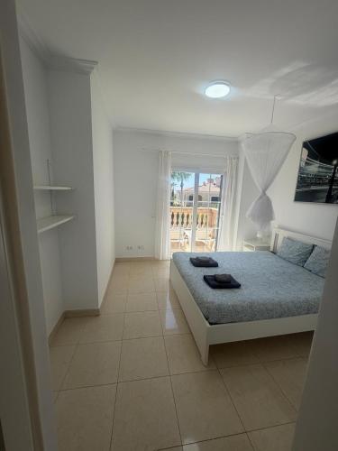a white bedroom with a bed and a window at Villa Mares Puig in Llucmajor