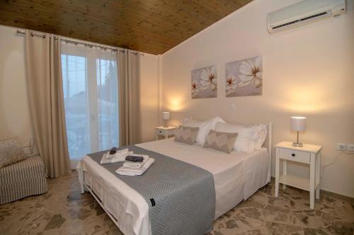 a bedroom with a large white bed and a window at Alivio Country House in Nafplio