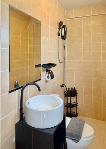 a bathroom with a sink and a mirror and a toilet at Simply Stay Chaweng in Chaweng