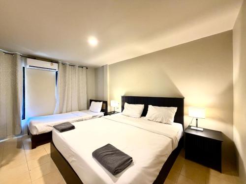 a hotel room with two beds and a window at Simply Stay Chaweng in Chaweng