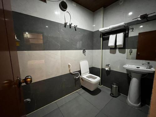 a bathroom with a toilet and a sink at Emporia comforts in Devanhalli