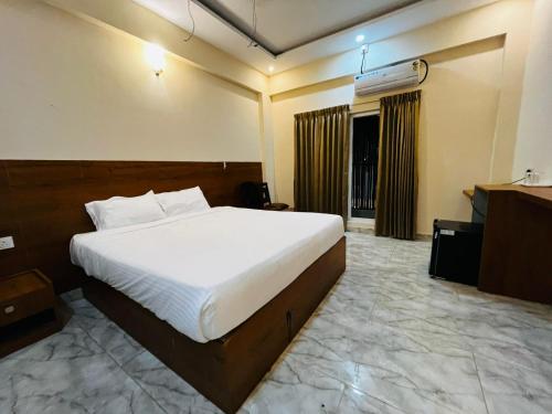 a hotel room with a bed and a television at Emporia comforts in Devanhalli