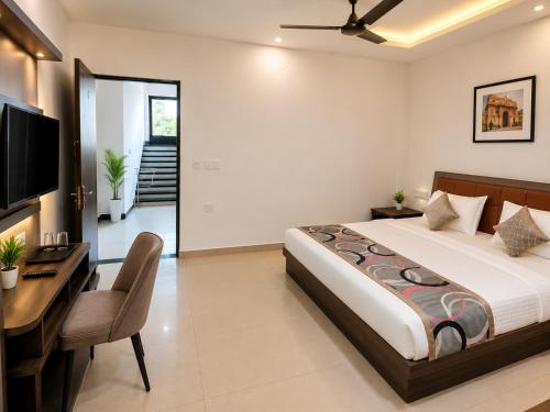a bedroom with a bed and a desk and a television at Hotel Shekhawati Resort -Parking Restaurant Near Toran Dwar in Khātu