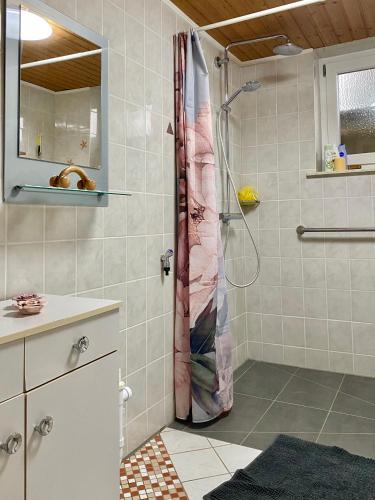 a bathroom with a shower with a shower curtain at FeWo im Dreiländereck in Büchlberg