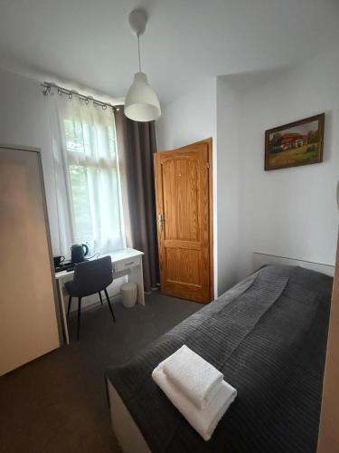 a bedroom with a bed and a desk and a window at Pokoje Gościnne U Niny - Szklarska Poręba in Szklarska Poręba