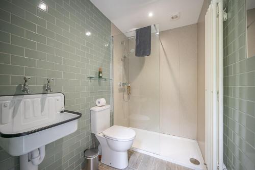 a bathroom with a toilet and a sink and a shower at Toad Hall Lodges - Luxury Glamping Lodges Near Southwold! in Wangford