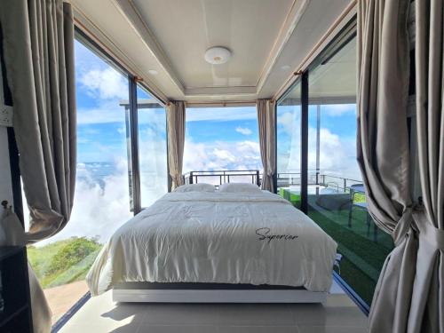 a bedroom with a bed in front of a large window at Memory เมมโมรี่ ภูทับเบิก in Ban Maeo Thap Boek