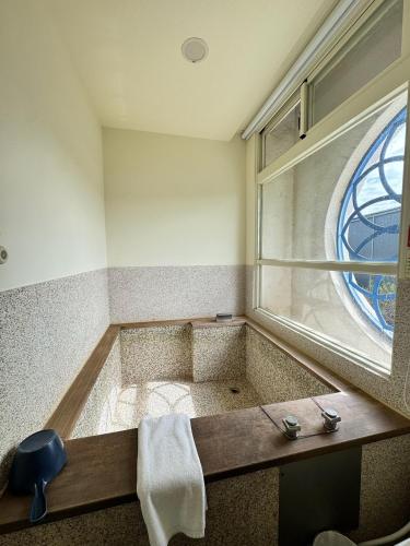 a bathroom with a bath tub with a window at 星月文旅民宿 in Houli