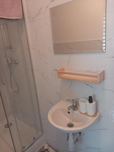 a bathroom with a sink and a shower at Noclegi Puńsk w centrum 50 m in Puńsk