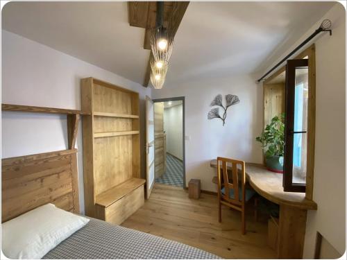 a bedroom with a bed and a desk and a table at Appartement chaleureux cité vauban à Briançon in Briançon