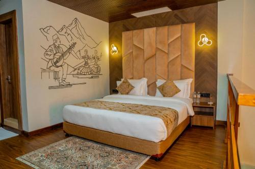 a bedroom with a bed with a drawing on the wall at Gautam Hotel Dhanusha in Lālbhitti