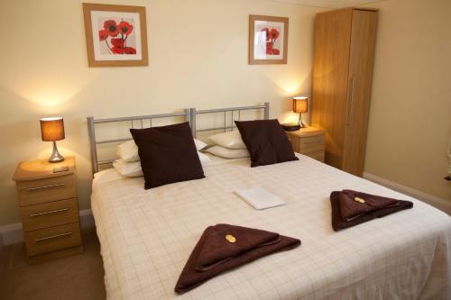 a bedroom with a bed with two brown towels on it at Cranston House in East Grinstead
