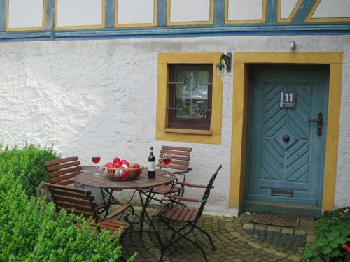 a table with a bowl of fruit and a blue door at Ferienwohnungen Haus Hinneres in Schalkenmehren