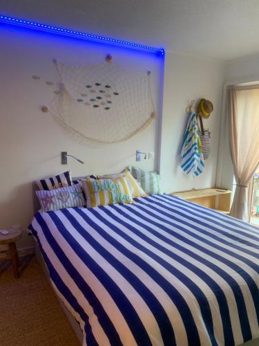 a bedroom with a blue and white striped bed at Nyons Riviera in Nyons
