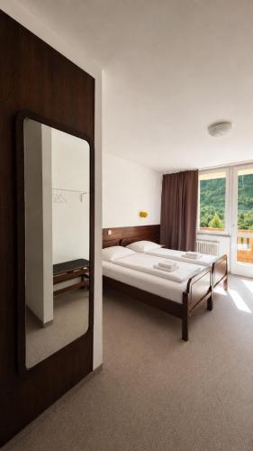 a bedroom with a bed and a large mirror at Hotel Lucija in Most na Soči