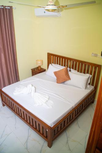 a bedroom with a bed with white sheets and pillows at Bandari House Malindi in Zanzibar City