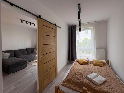 a bedroom with a bed and a sliding door at Apartament Bulwary 7 in Oświęcim