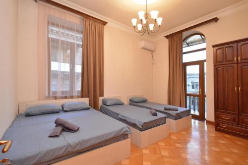 a bedroom with two beds and a chandelier at Tumanyan Guesthouses in Yerevan