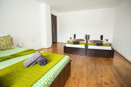 two beds in a large room with wooden floors at casa hermosa in Turda