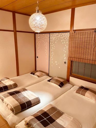 a bedroom with three beds in it with a chandelier at Love Kyoto Kyoenkan in Kyoto