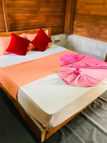 a bed with two dresses on top of it at Rooms at Maduka Restaurant in Ilandaiyadi