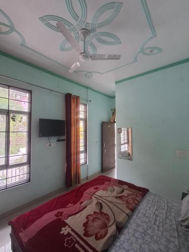 a bedroom with a bed and a ceiling fan at K C Hotel & Restaurant in Rudraprayāg